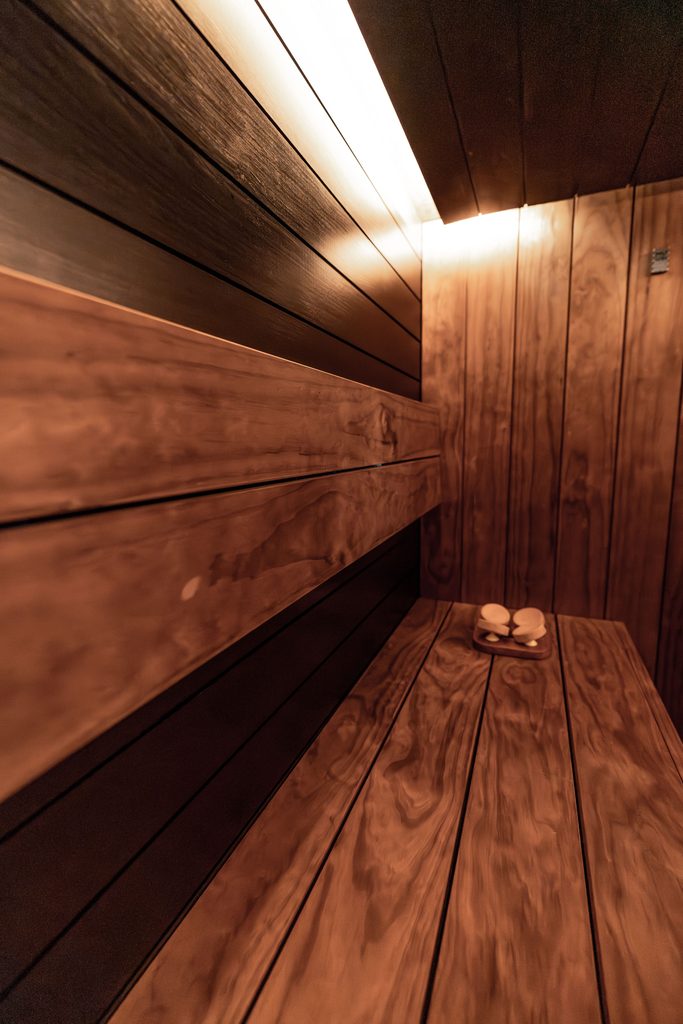 Corner infrared sauna with dark wood interior